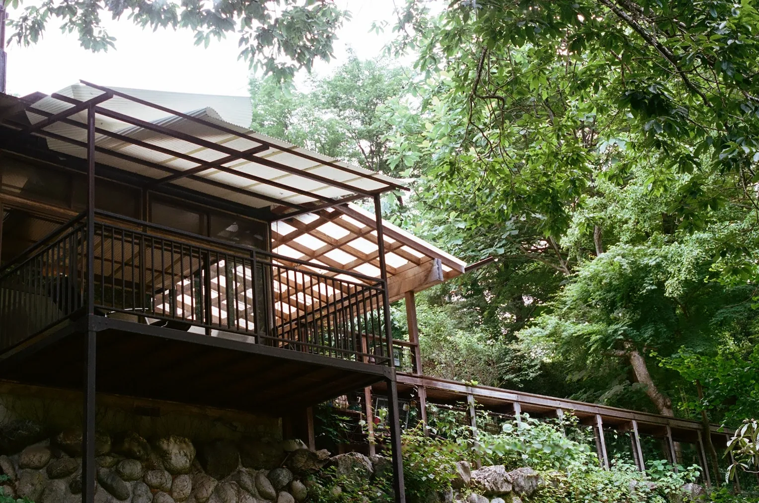The balcony of a house made out of wood and brown metal.