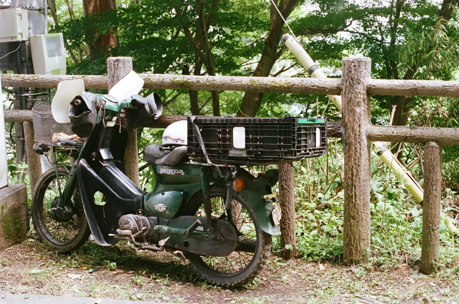 An old, green Honda motorbike parked by the trail.